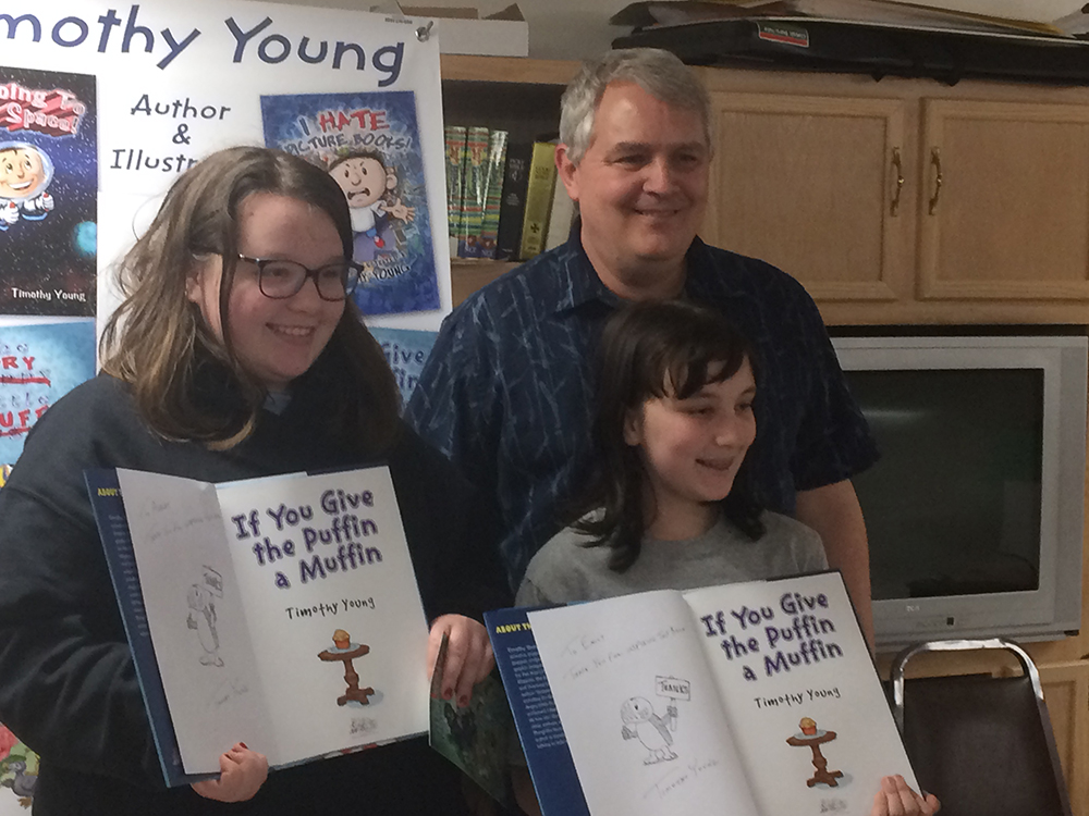 Ashley Nietupski and Emily Horvath get signed copies thanking them for being the inspiration for author/illustrator timothy Young's If You Give the Puffin a Muffin